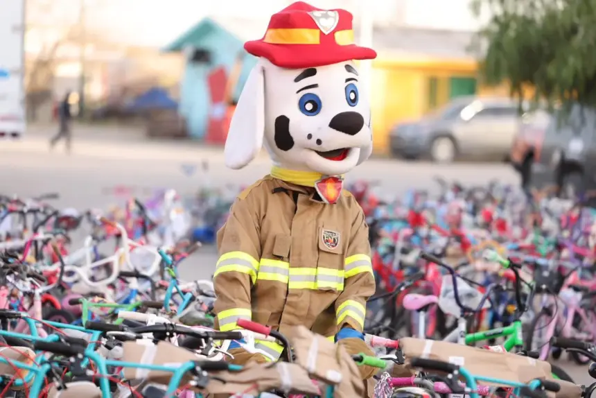 Eduardo Medina, quien formó fila por tres días, recibe bicicletas para sus hijos como parte de la campaña 'Santa Bombero'.